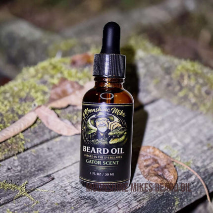 Moonshine Mike's Gator Scent Beard Oil bottle on a countertop with grooming tools.