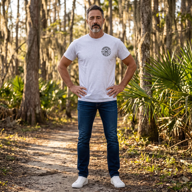 Fort Denaud Beard and Skin grey cotton t-shirt with Moonshine Mike's logo worn by a man on a forest trail