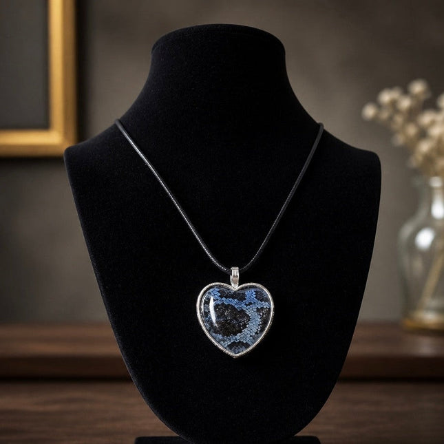 Fort Denaud Beard and Skin heart pendant necklace with blue and black snakeskin pattern on a black cord display bust