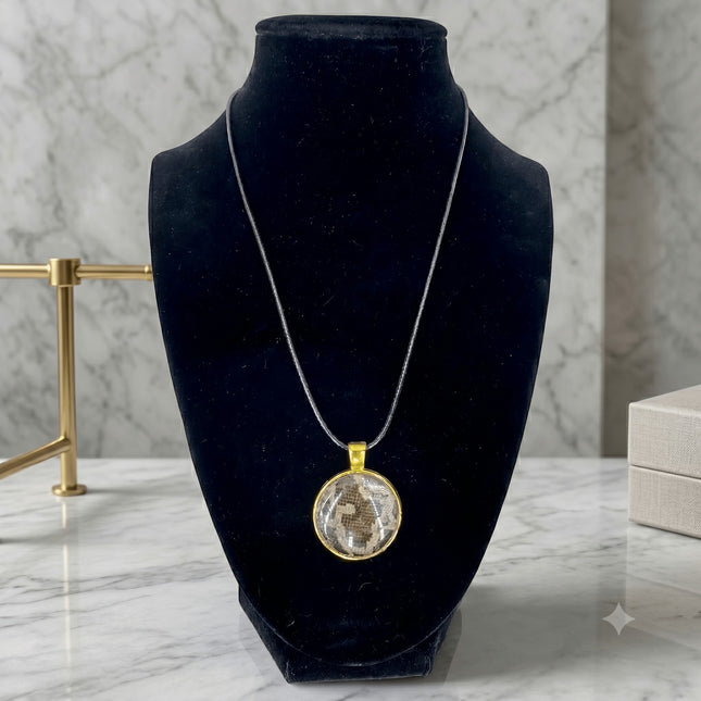 Fort Denaud Beard and Skin round pendant necklace with textured inlay in a gold-tone setting on a black cord
