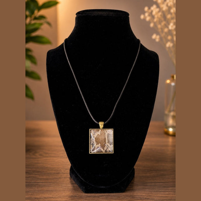 Fort Denaud Beard and Skin square pendant necklace with a snakeskin pattern in an antique bronze setting on a black cord