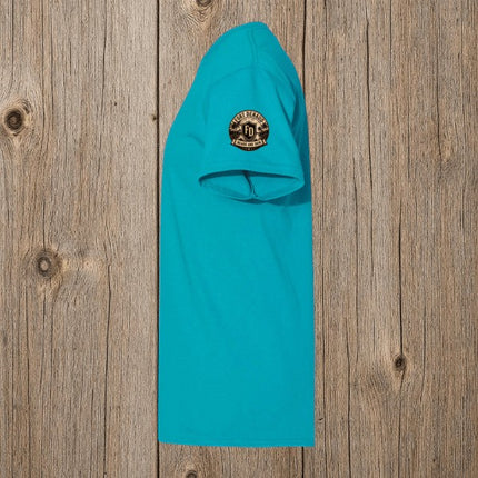 Fort Denaud Beard and Skin turquoise cotton t-shirt with a circular logo graphic on the sleeve, side view.